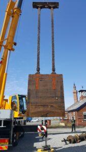Large wooden crate being held up by a crane lift